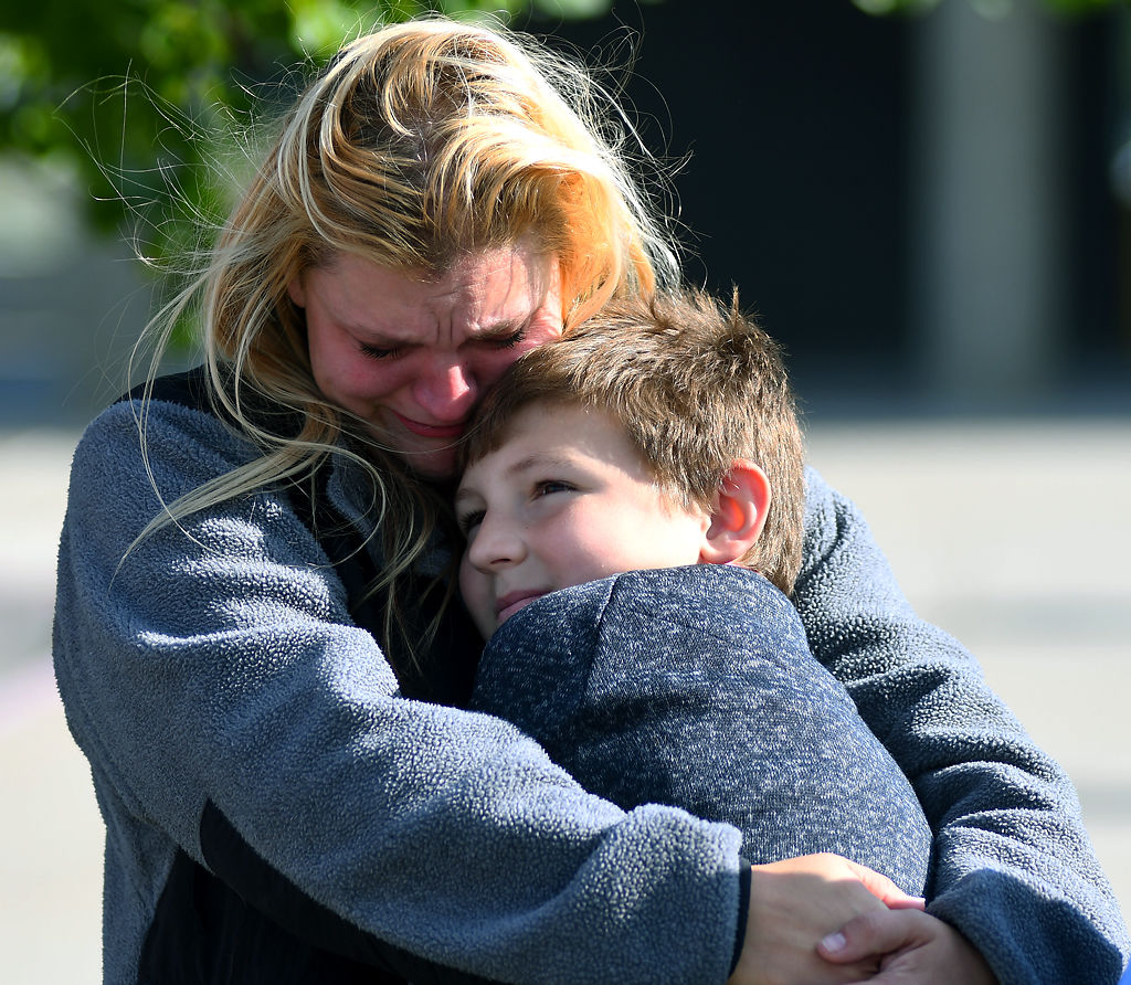 Gabriella Curry's mom, Cheyenne Curry, hugs her son and Gabriella's older brother, Tristan Curry